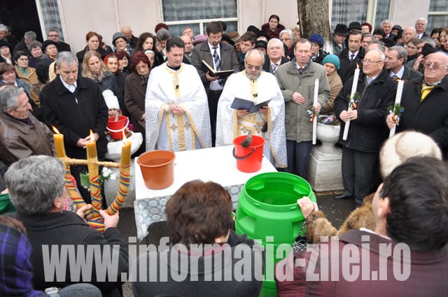 parintele Ioan Socolan stropind cu apa sfintita credinciosii