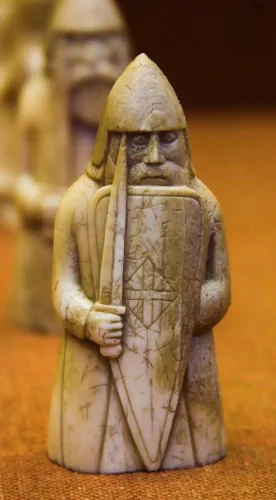 O piesă din tezaurul de șah Lewis, interpretată în mod obișnuit ca un berserker viking, prin Wikimedia commons